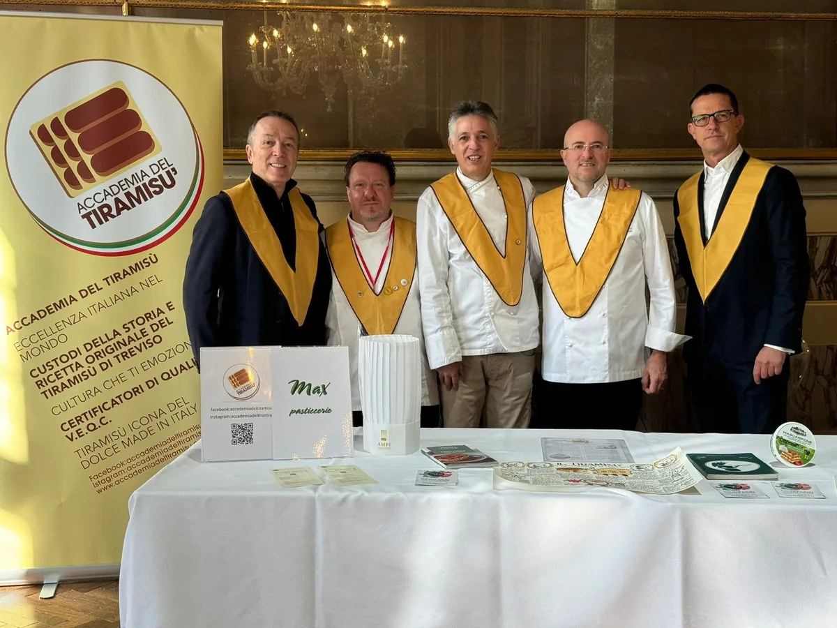 Five members of the Accademia del Tiramisù wearing the golden sash at the Casinò di Venezia, behind the Academy stand